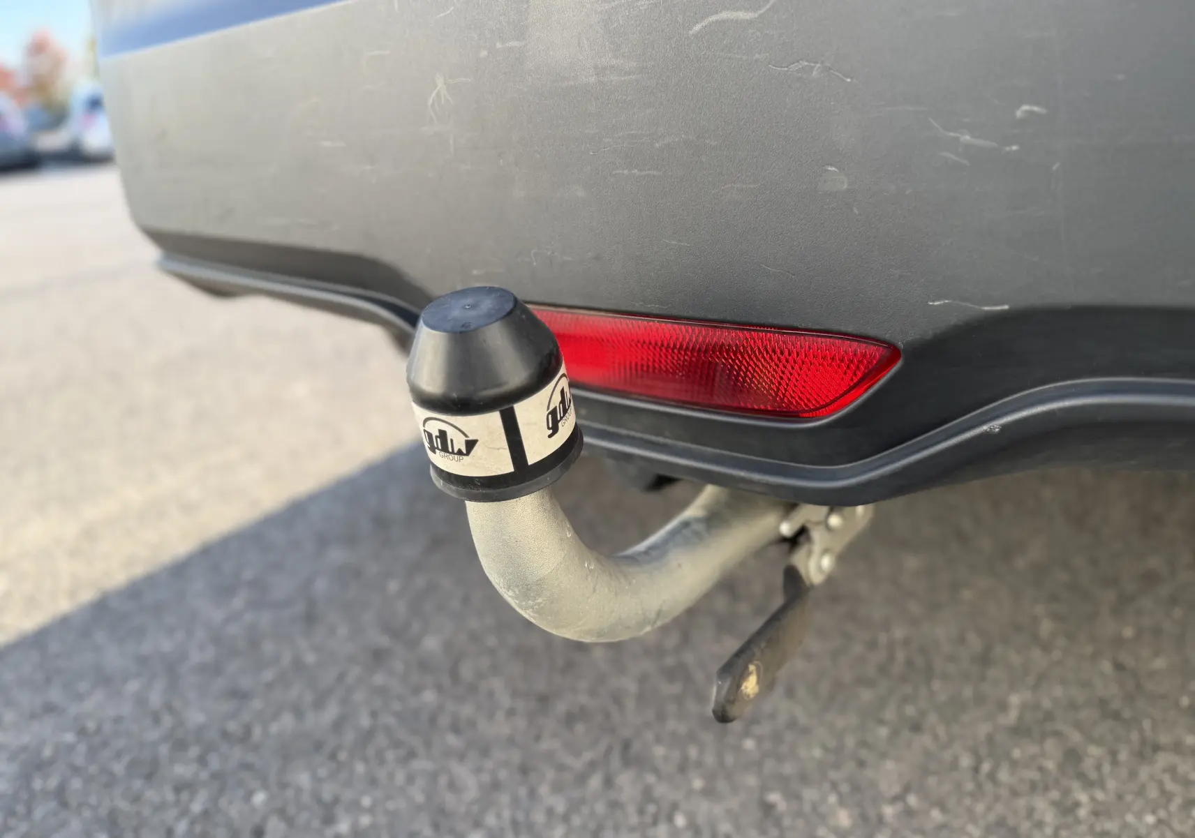 Gros plan sur l'attelage arrière d'un Toyota C-HR bleu Nebula Metal avec feu rouge intégré au pare-chocs.