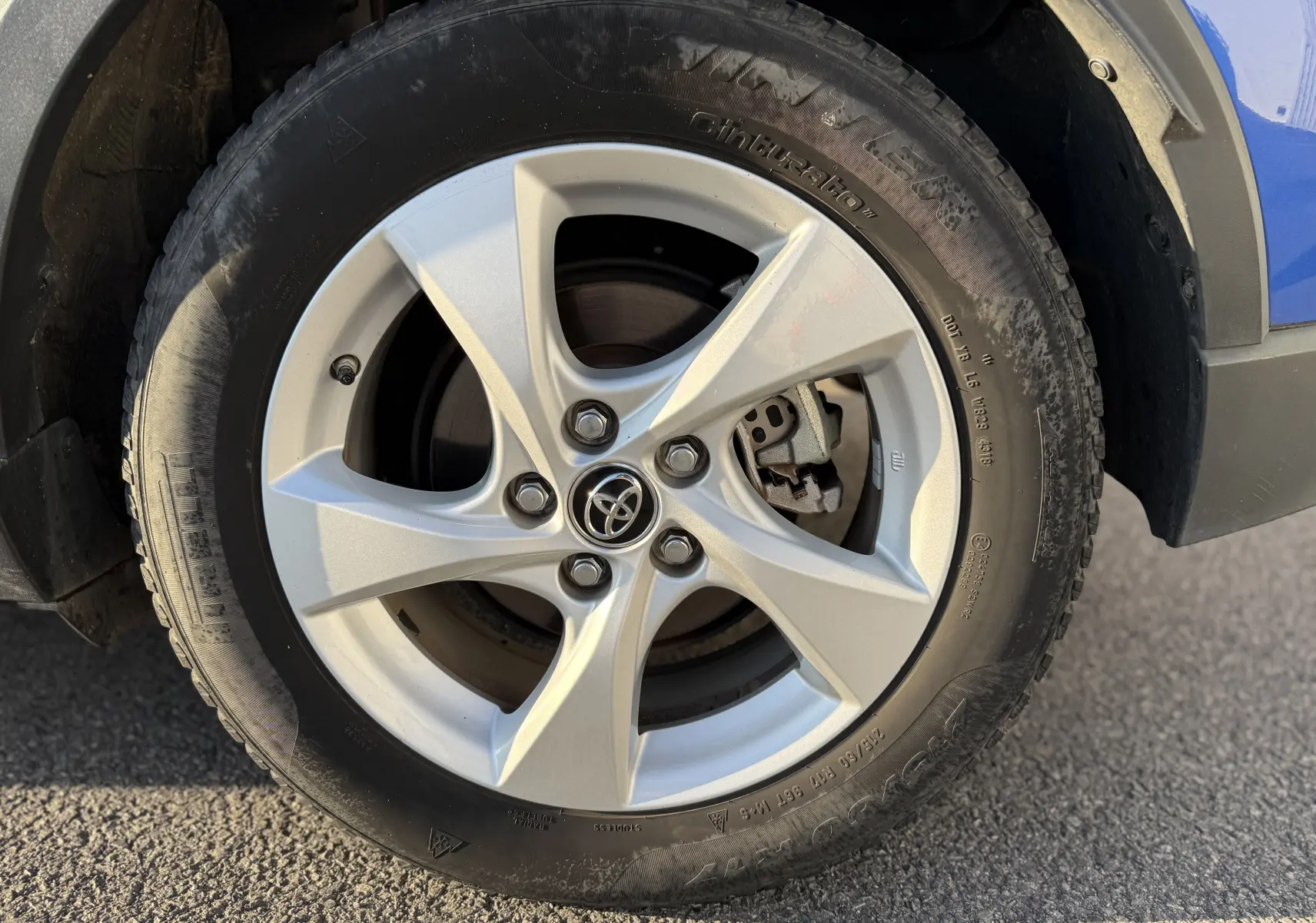 Gros plan sur la roue avant gauche du Toyota C-HR bleu Nebula Metal, mettant en valeur la jante alliage 5 branches et le pneu hiver.