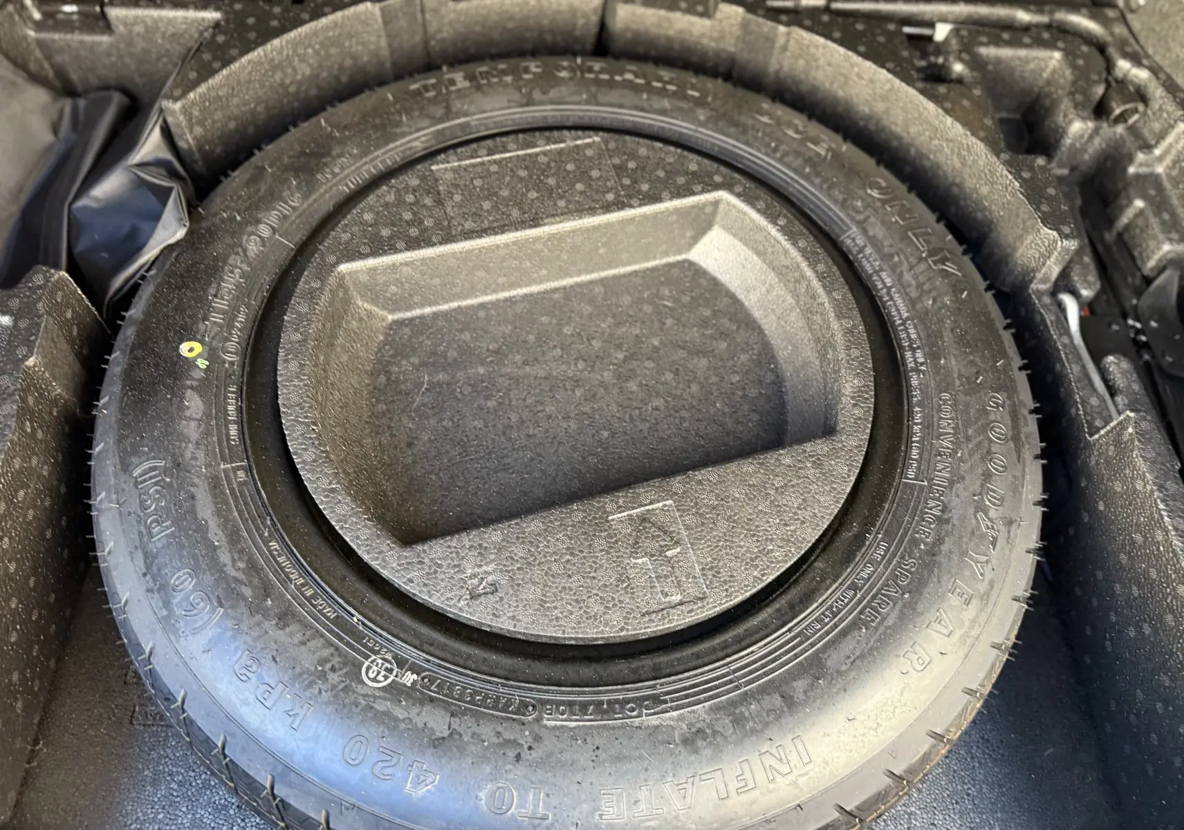 Pneu de secours Goodyear dans le coffre du Toyota C-HR 1.8 Hybrid 2018, vue en plongée sur le rangement intégré.