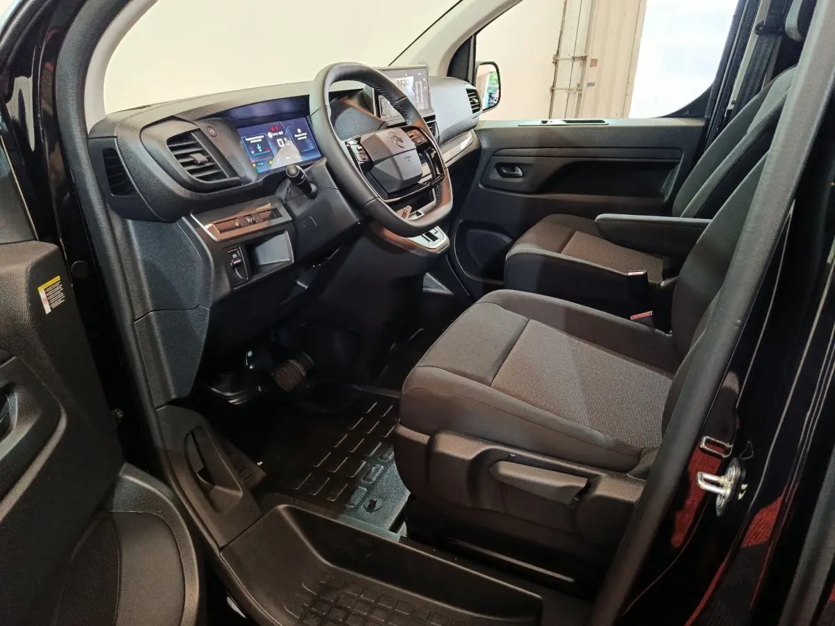 Vue intérieure côté conducteur du Citroën Jumpy XL noir 2025, montrant le tableau de bord et les sièges avant.