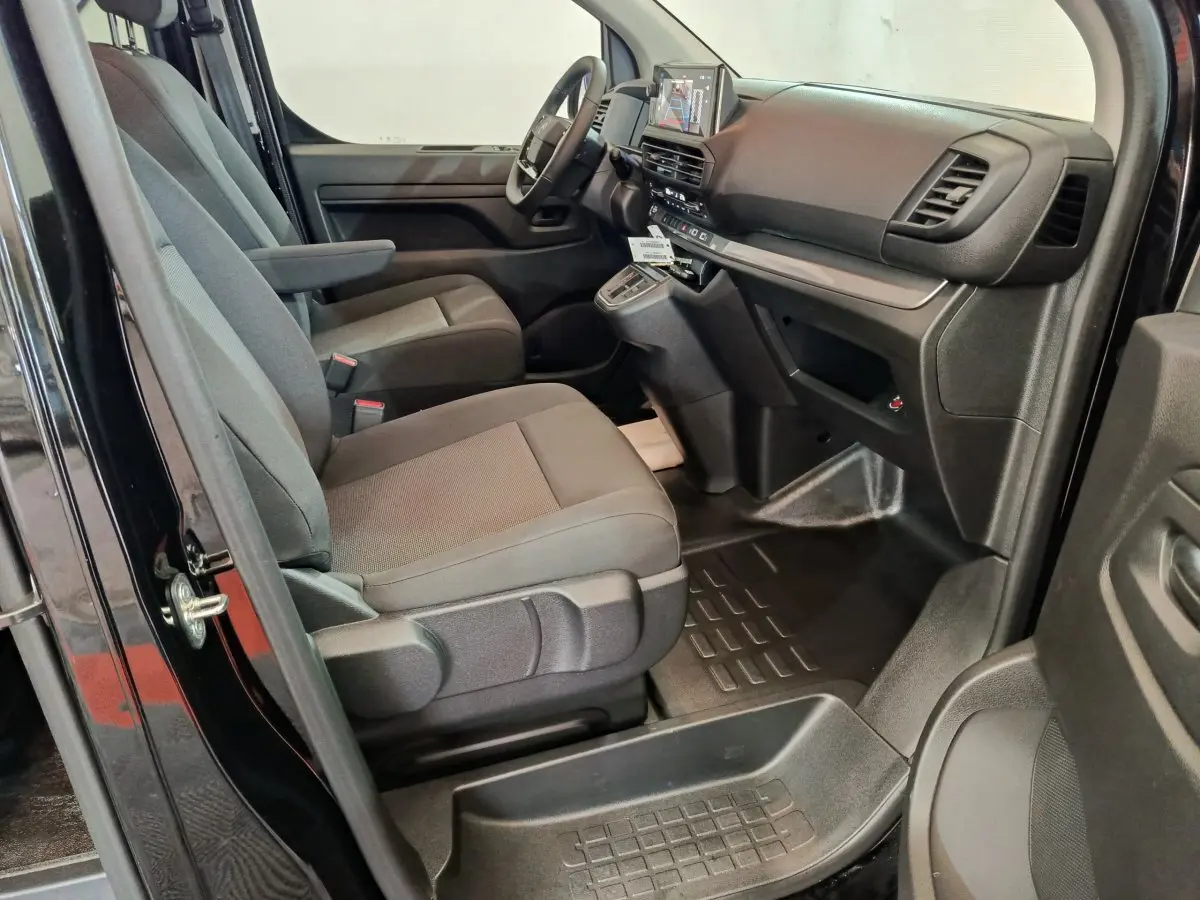 Vue intérieure côté conducteur du Citroën Jumpy XL noir 2025, montrant les sièges avant et le tableau de bord moderne.