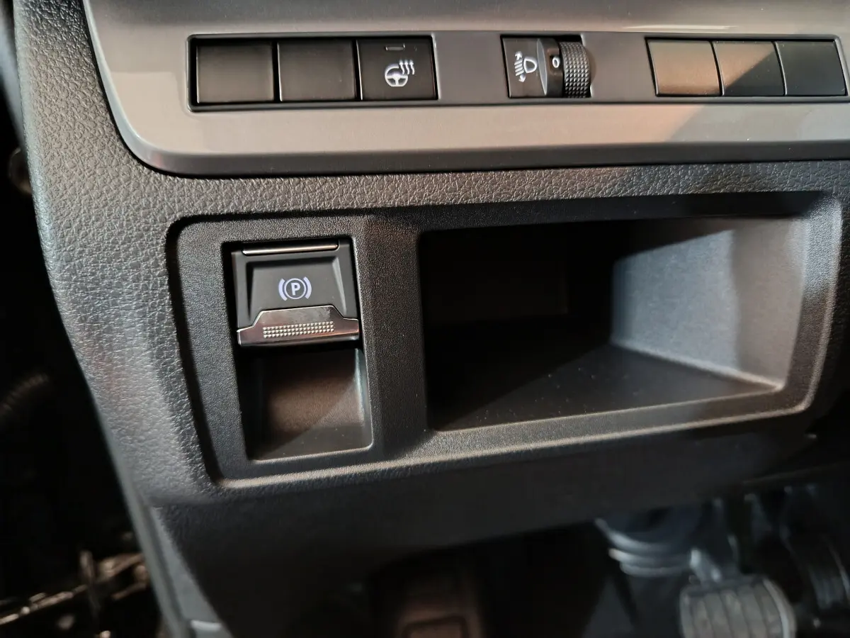 Détail du tableau de bord noir du Citroën Jumpy XL 2025, avec bouton de frein à main électrique et commandes d'éclairage.
