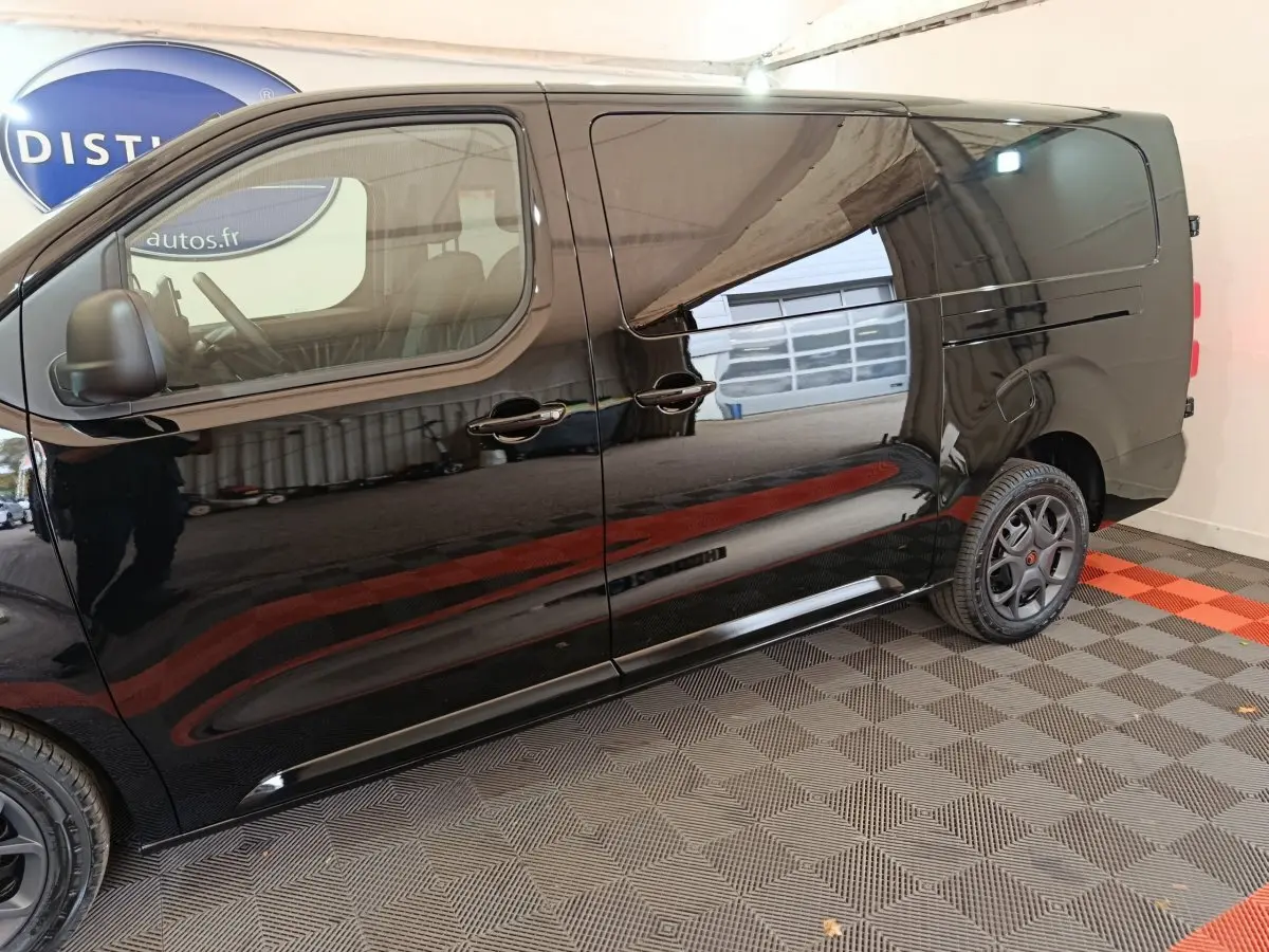 Vue de profil côté gauche du Citroën Jumpy XL noir, mettant en valeur sa carrosserie lisse et ses jantes noires.