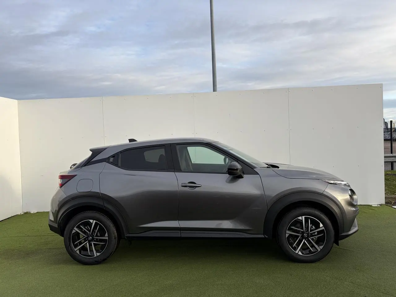 Profil droit du Nissan Juke II 1.6 Hybrid 143 N-Connecta en noir métal avec jantes alliage 17 pouces.
