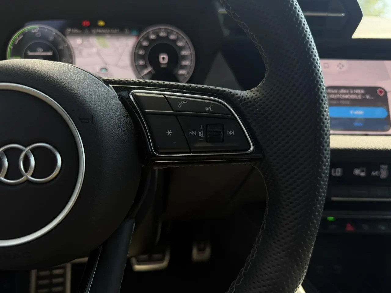 Gros plan sur le volant en cuir perforé noir avec commandes multifonctions de l'Audi A3 Sportback 2025.