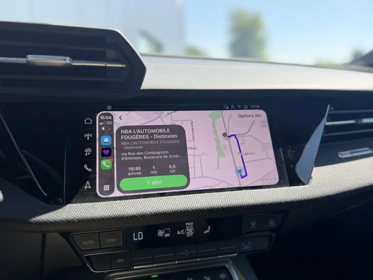 Écran tactile central de l'Audi A3 Sportback noir Mythe, affichant la navigation avec interface moderne et commandes climatisation.