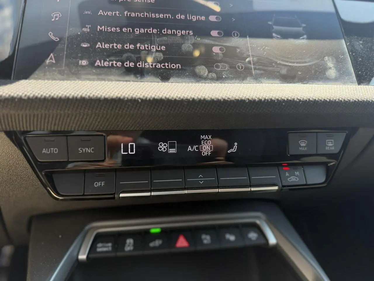 Gros plan sur la console centrale de l’Audi A3 Sportback 2025, affichage climatisation et commandes tactiles noires.