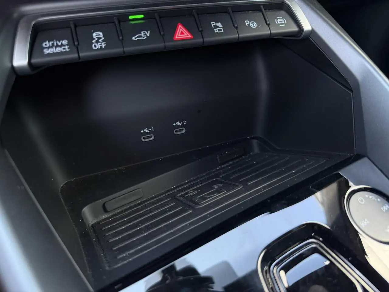Gros plan sur la console centrale noire de l'Audi A3 Sportback 2025 avec boutons de contrôle et ports USB-C visibles.