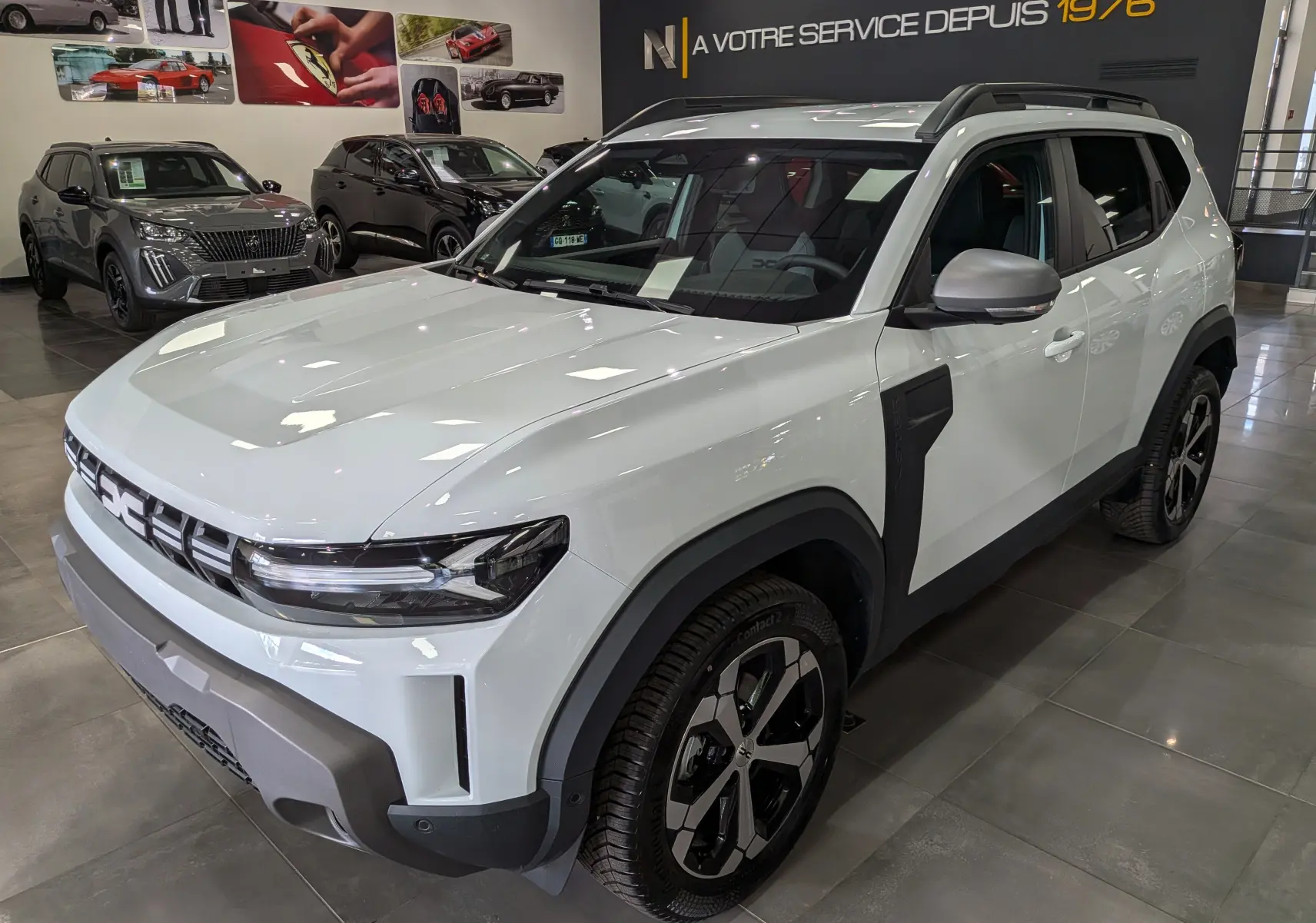 Vue 3/4 avant droit d'un Dacia Duster Hybrid-G blanc Glacier avec jantes bi-ton et détails noirs contrastants.