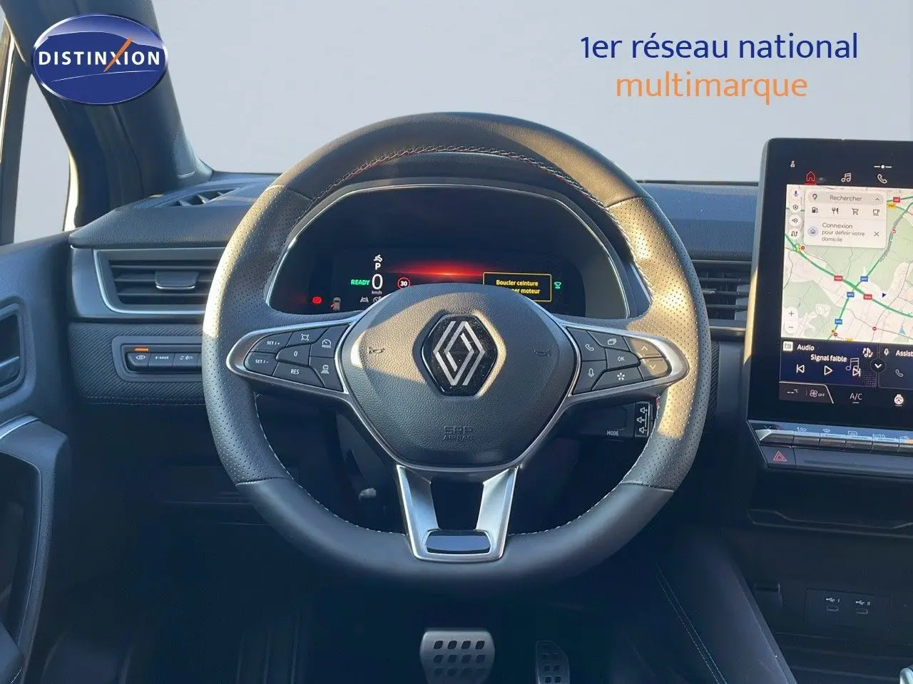 Vue centrée sur le volant en cuir noir du Renault Captur E-Tech hybride 2025 avec tableau de bord digital et écran tactile GPS.