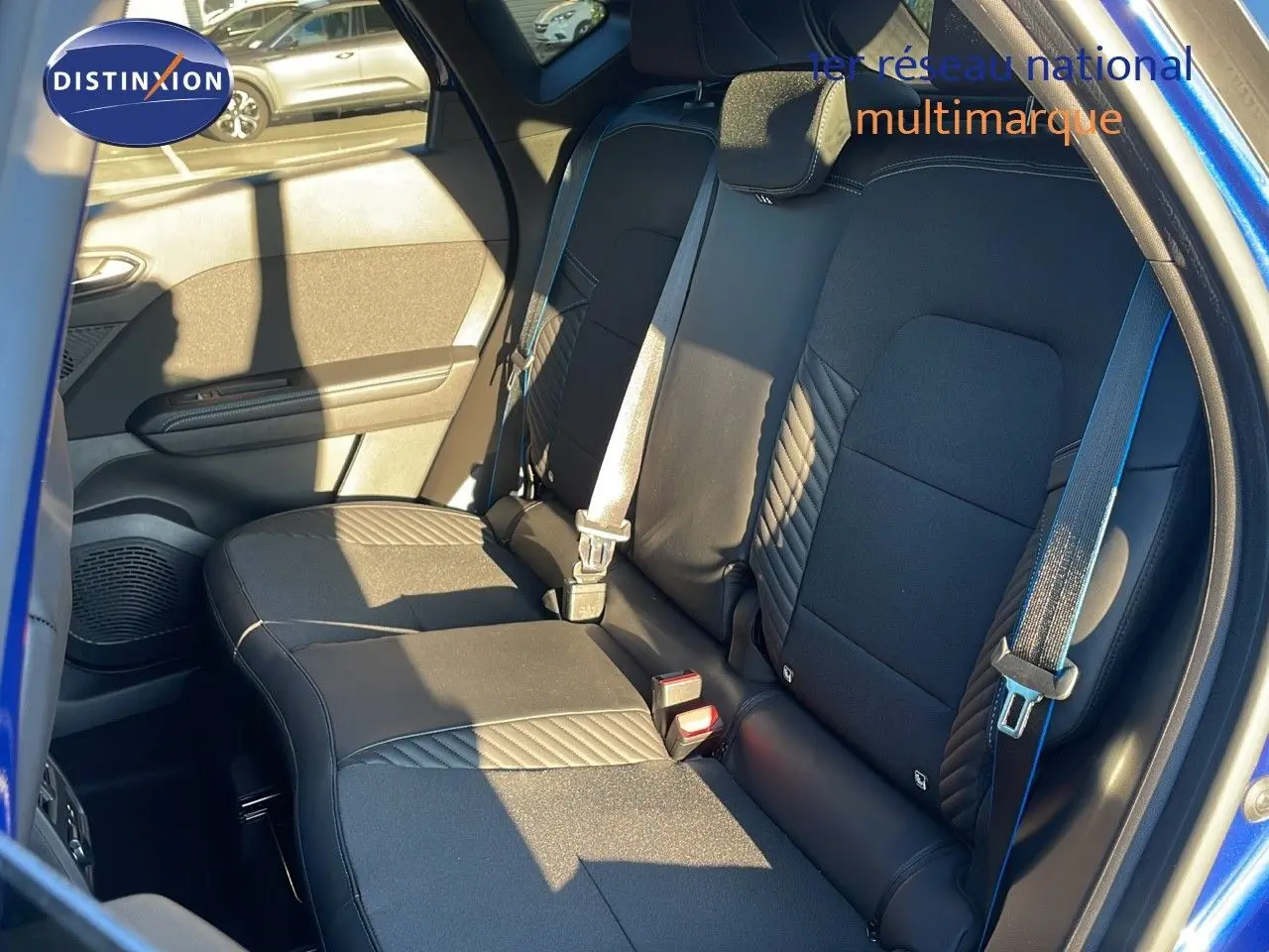 Vue intérieure arrière sur les sièges noirs avec surpiqûres bleues du Renault Captur E-Tech hybride 2025 toit noir.