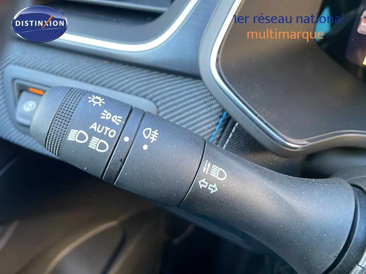 Gros plan sur la commande des feux et clignotants du Renault Captur E-Tech hybride 2025, intérieur noir texturé.