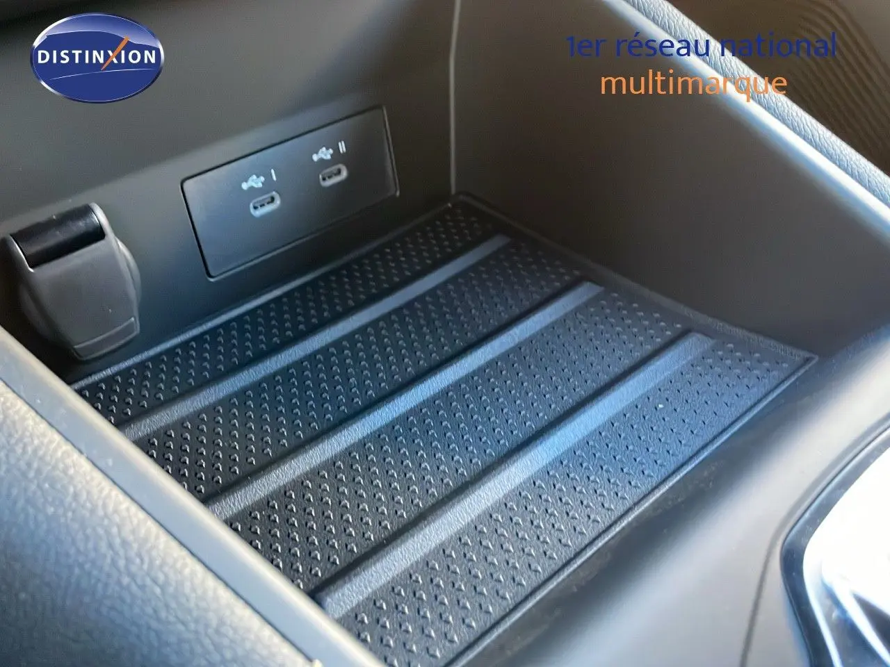 Gros plan sur la console centrale du Renault Captur 2025, montrant les ports USB et un espace de rangement noir texturé.