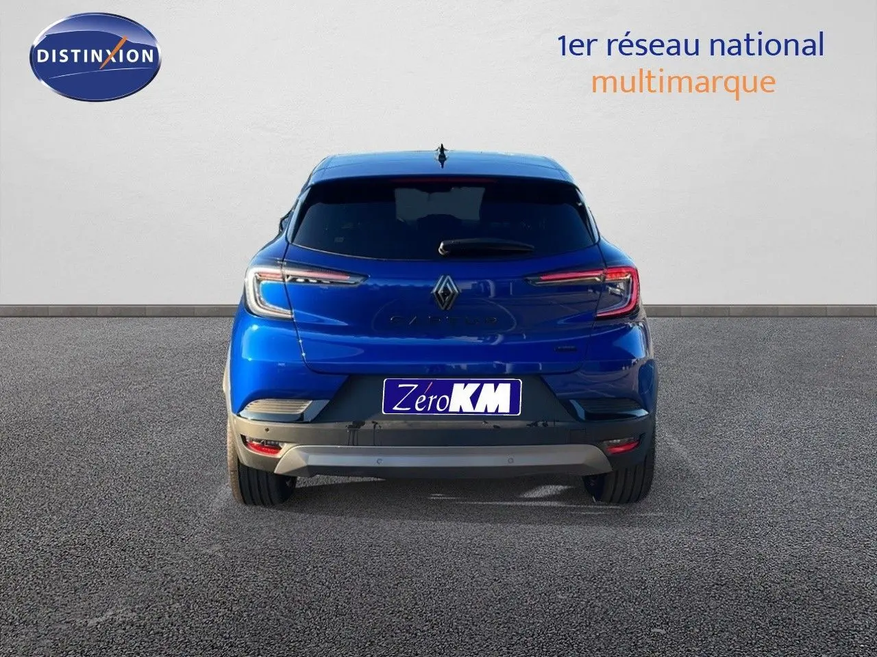 Vue arrière du Renault Captur E-Tech hybride 2025 en bleu Iron Metal avec toit noir, feux LED allumés.