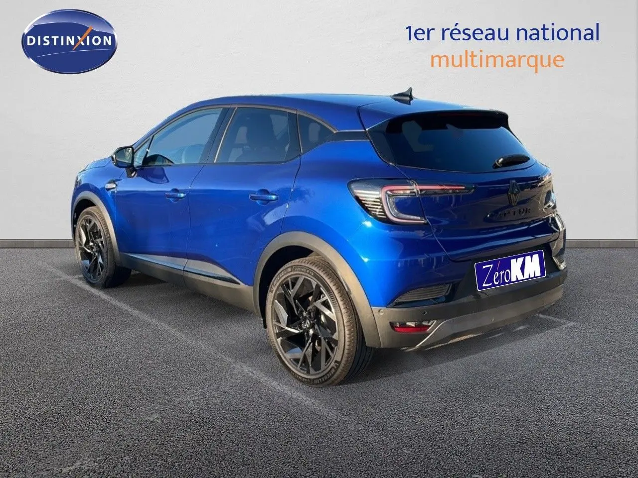 Vue 3/4 arrière droite d'un Renault Captur E-Tech hybride bleu Iron Metal avec toit noir et jantes noires.