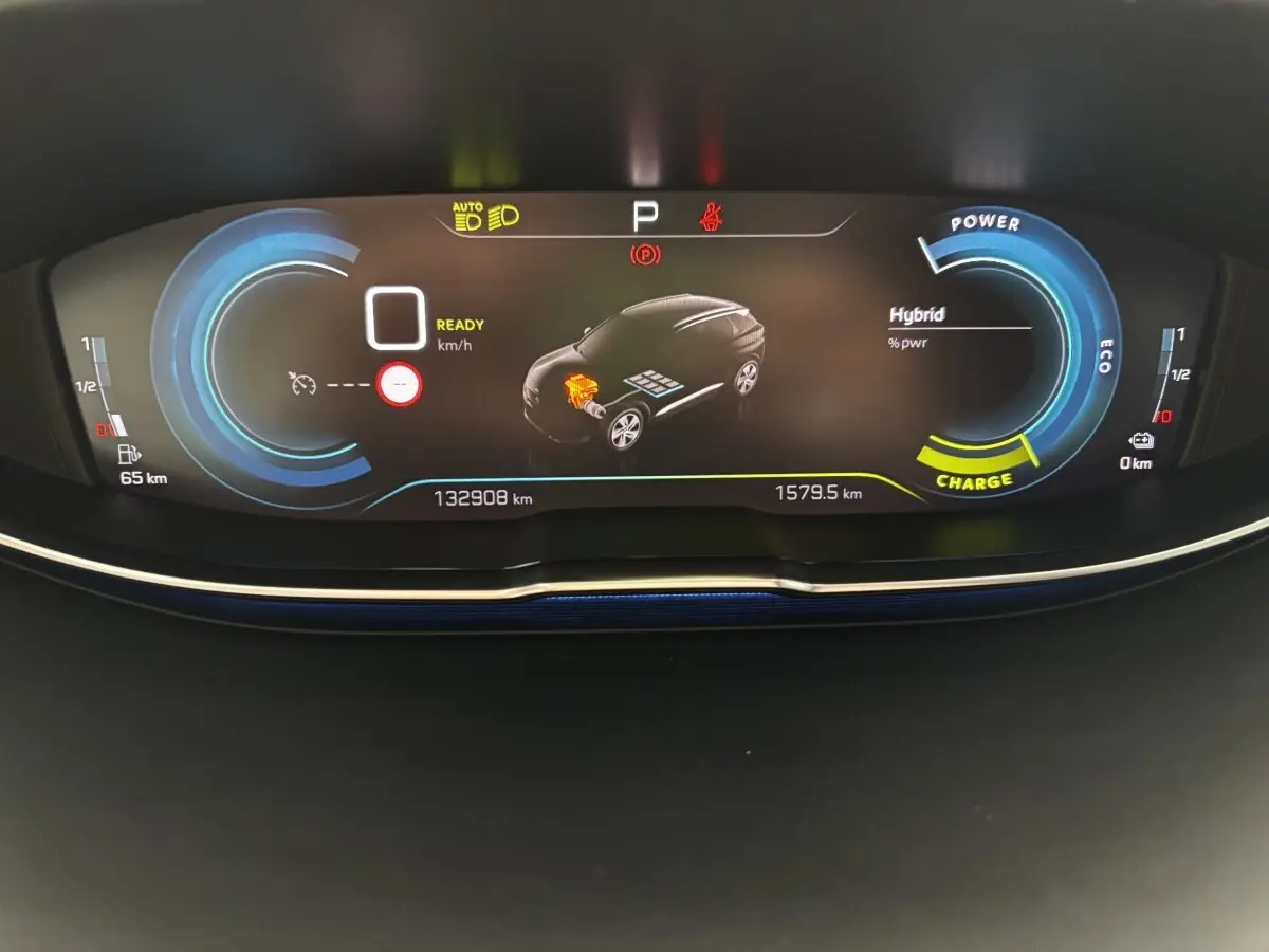 Affichage numérique du tableau de bord du Peugeot 3008 hybride, montrant l'état de charge et la consommation.