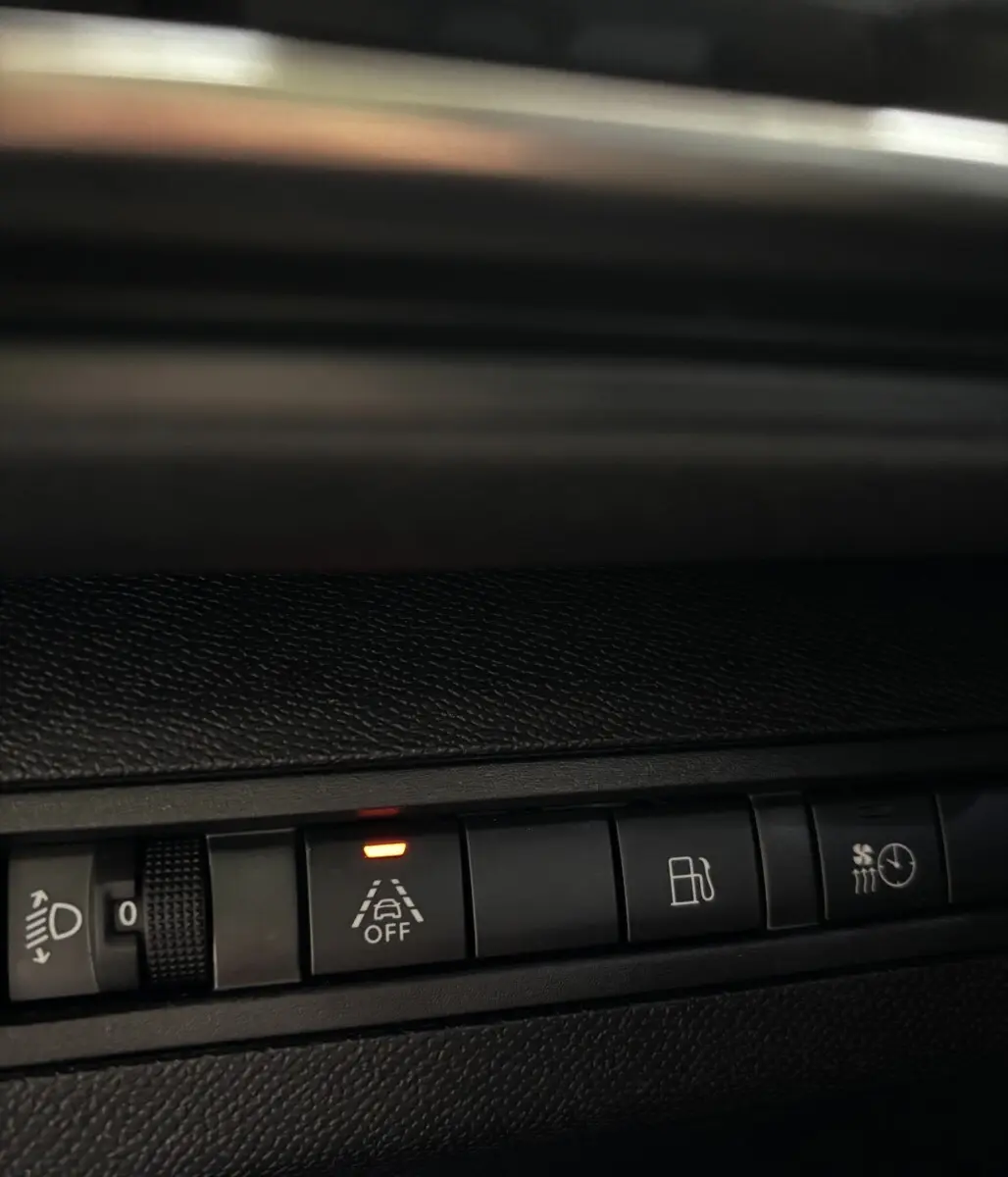 Gros plan sur les commandes du tableau de bord du Peugeot 3008 gris foncé, avec témoin d'alerte de maintien de voie éteint.