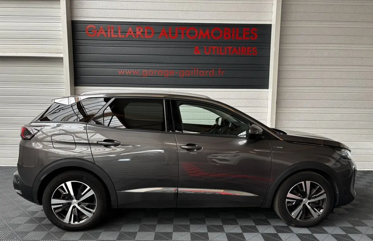 Profil côté gauche du Peugeot 3008 hybride rechargeable gris foncé avec jantes alliage et vitres teintées.