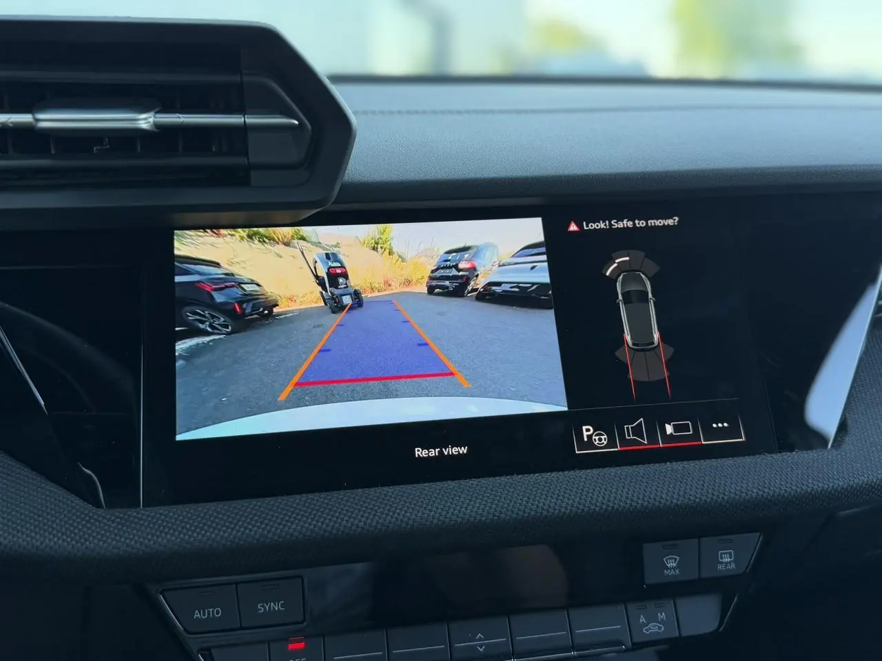 Écran intérieur affichant la caméra de recul et l'aide au stationnement d'une Audi A3 Sportback blanche Glacier.