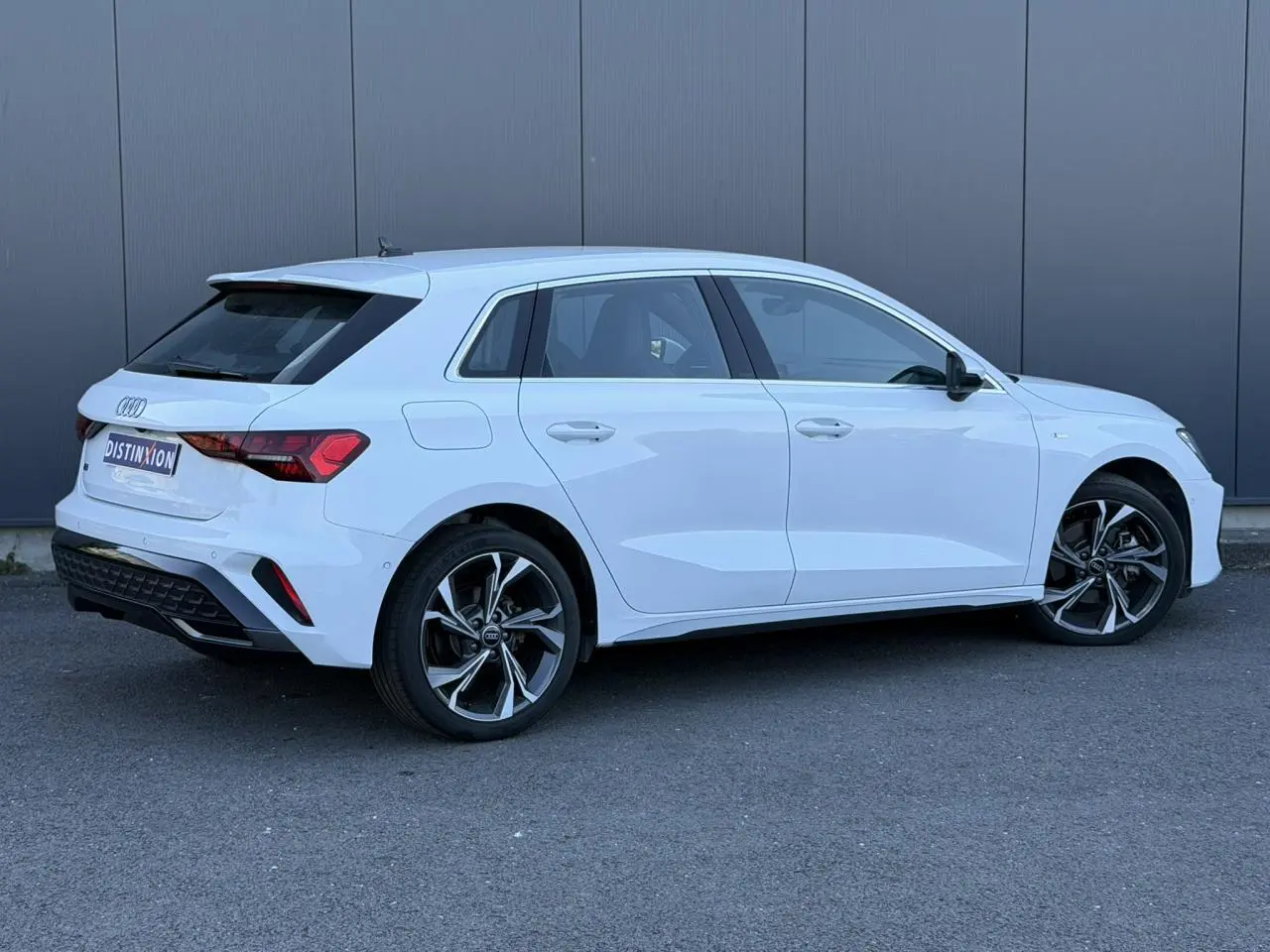 Audi A3 Sportback blanc glacier vue de profil côté droit avec jantes alliage 5 branches en Y et feux arrière LED distinctifs.