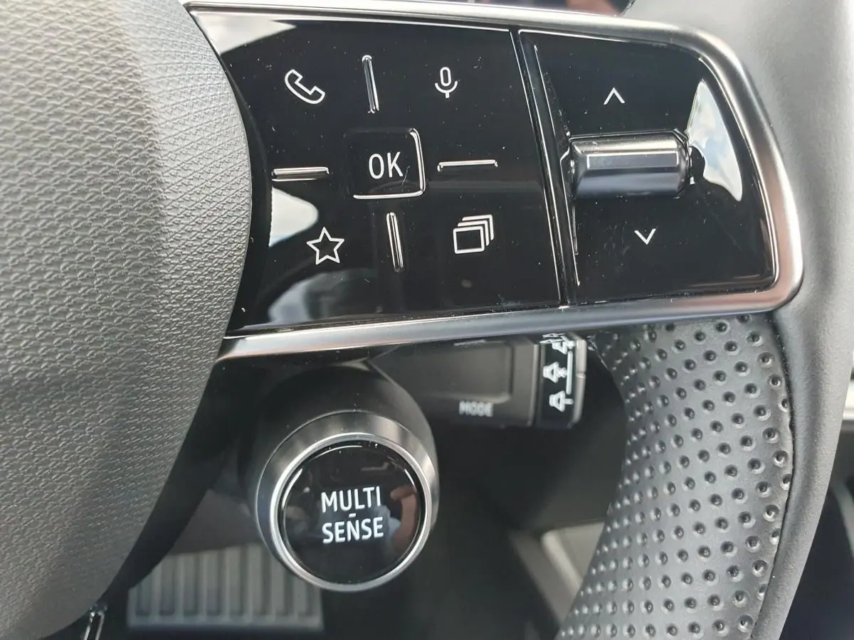 Gros plan sur le volant noir perforé de la Renault Clio VI avec commandes multifonctions et bouton MULTI-SENSE.