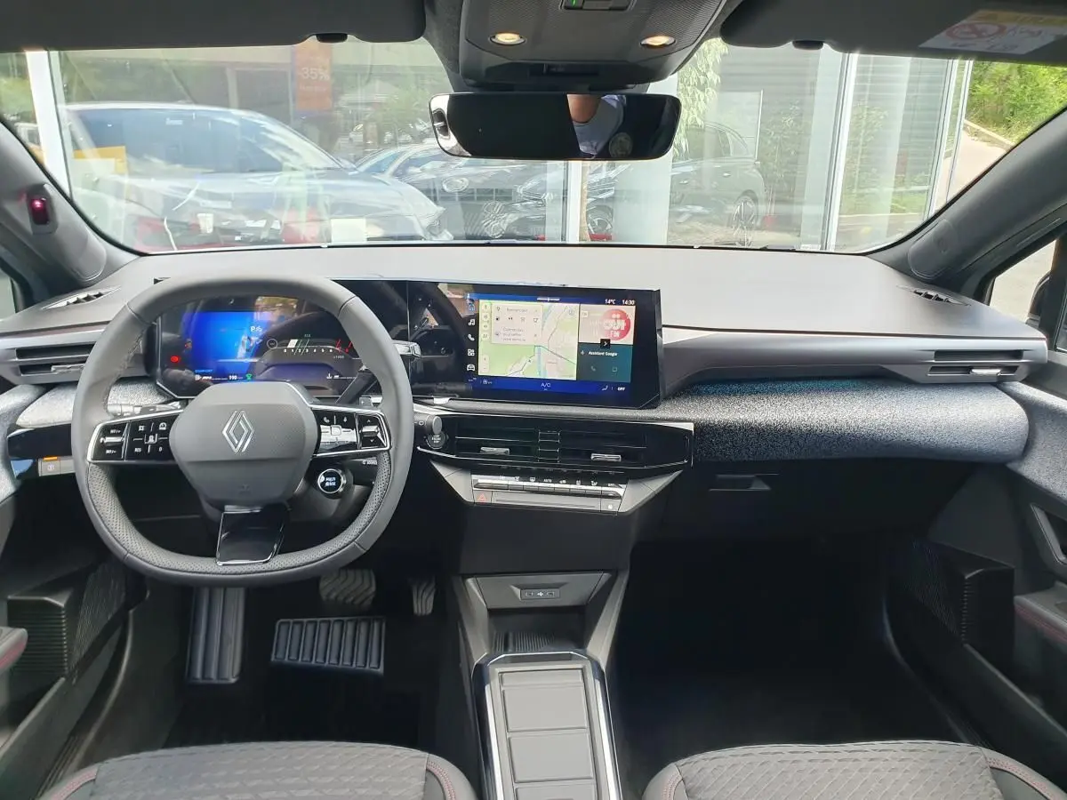 Vue intérieure avant de la Renault Clio VI avec tableau de bord numérique et écran tactile central.