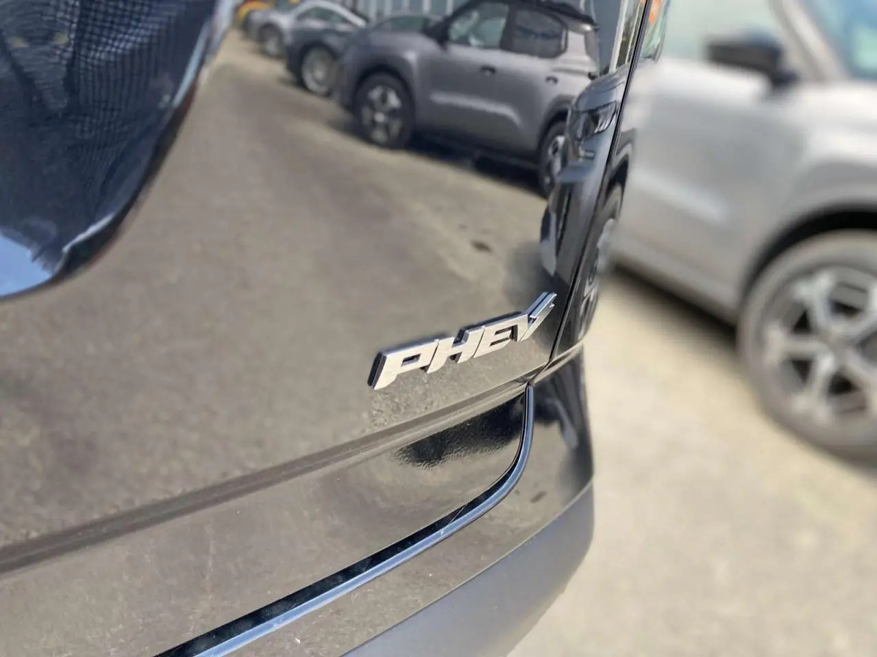 Gros plan sur l'arrière droit noir carbone brillant du JAECOO J7 1.5 PHEV avec le badge "PHEV" visible.