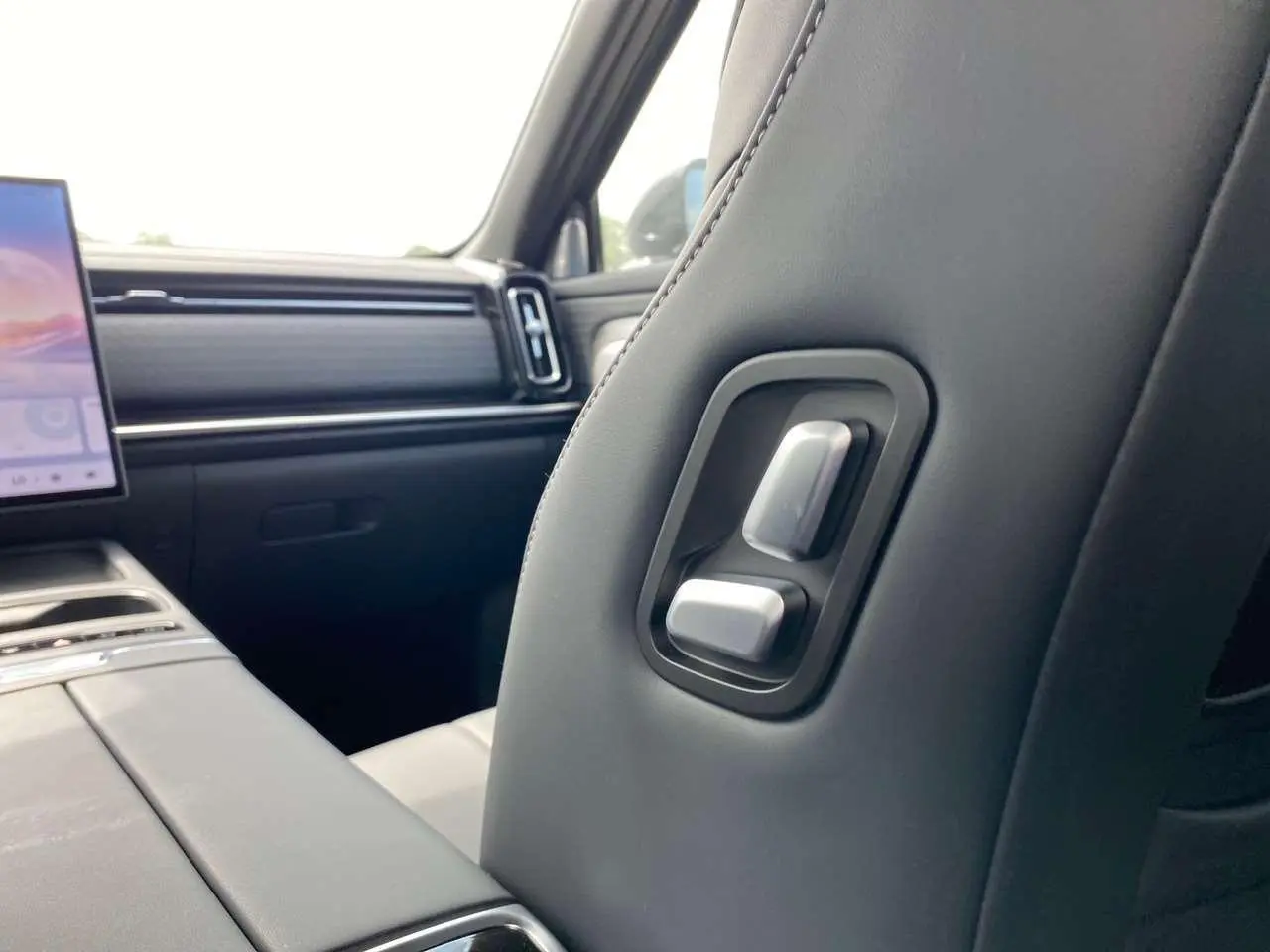 Vue intérieure rapprochée du siège avant droit du JAECOO J7 2026 en cuir noir avec commandes de réglage intégrées.