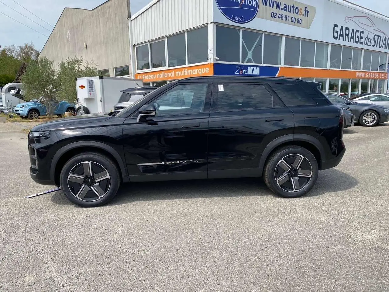 Vue de profil côté gauche du JAECOO J7 2026 en noir Carbon Cristal, avec ses jantes au design moderne et carrosserie lisse.