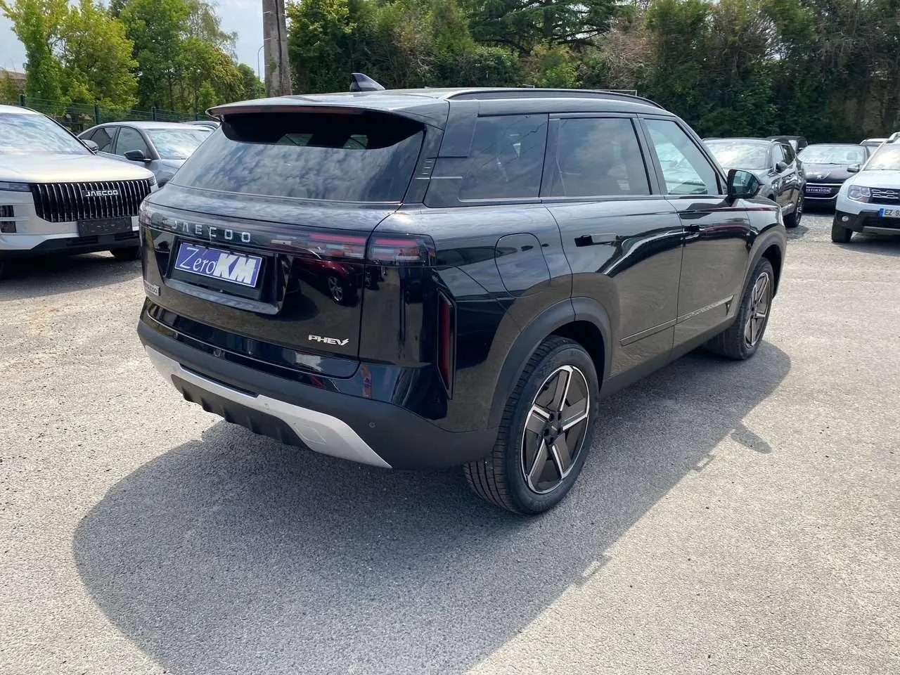 Vue 3/4 arrière droite du SUV JAECOO J7 1.5 PHEV Selective noir brillant avec feux arrière horizontaux et jantes modernes.