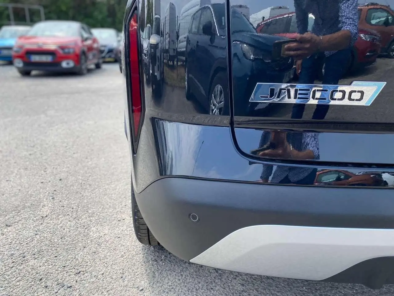 Gros plan sur l’arrière droit noir brillant du JAECOO J7 1.5 PHEV avec logo distinctif et feu arrière vertical rouge.
