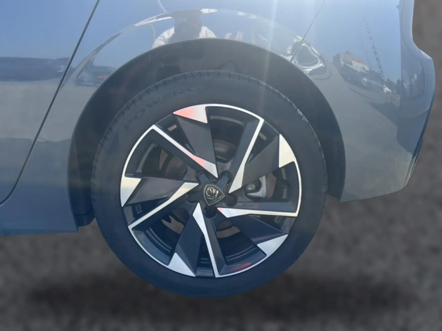Gros plan sur la roue arrière droite d'une Peugeot 308 gris selenium avec jante alu au design moderne.