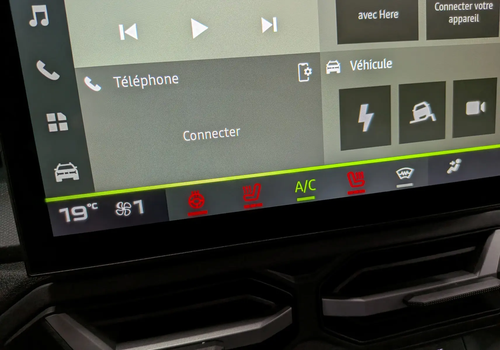 Écran tactile du tableau de bord du Dacia Duster Hybrid-G 150 CH 4x4, affichant les commandes de climatisation et connectivité.