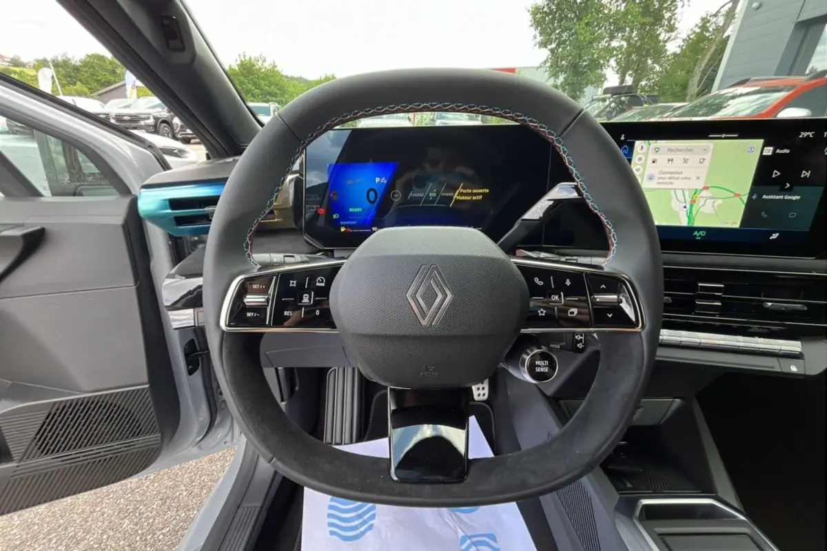 Vue intérieure centrée sur le volant cuir multifonctions de la Renault Clio 6 E-Tech 160 Esprit Alpine gris rafale, avec écran digital.