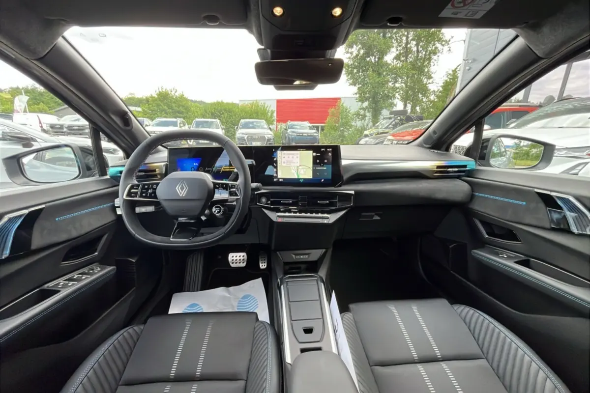 Vue intérieure avant de la Renault Clio 6 E-Tech 160 Esprit Alpine, tableau de bord noir avec écran tactile et volant multifonctions.