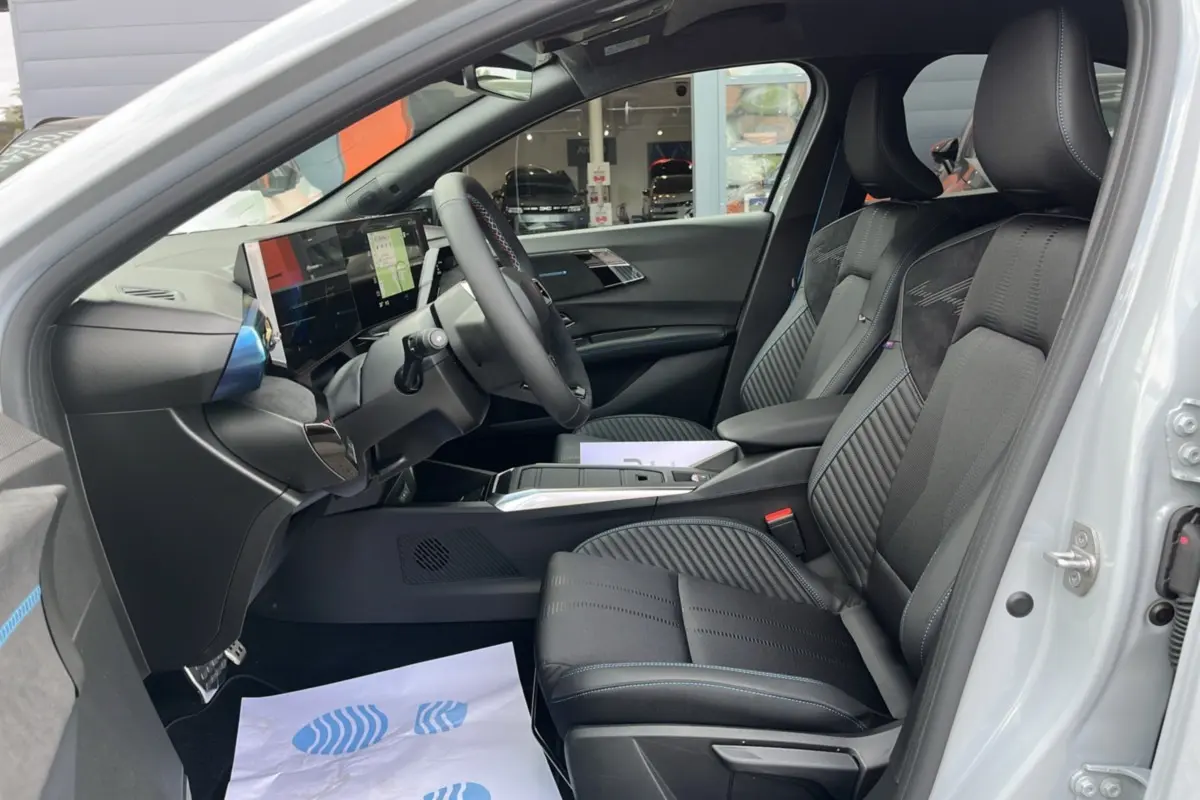 Vue intérieure côté conducteur de la Renault Clio 6 E-Tech 160 Esprit Alpine avec sièges sport noirs et tableau de bord digital.