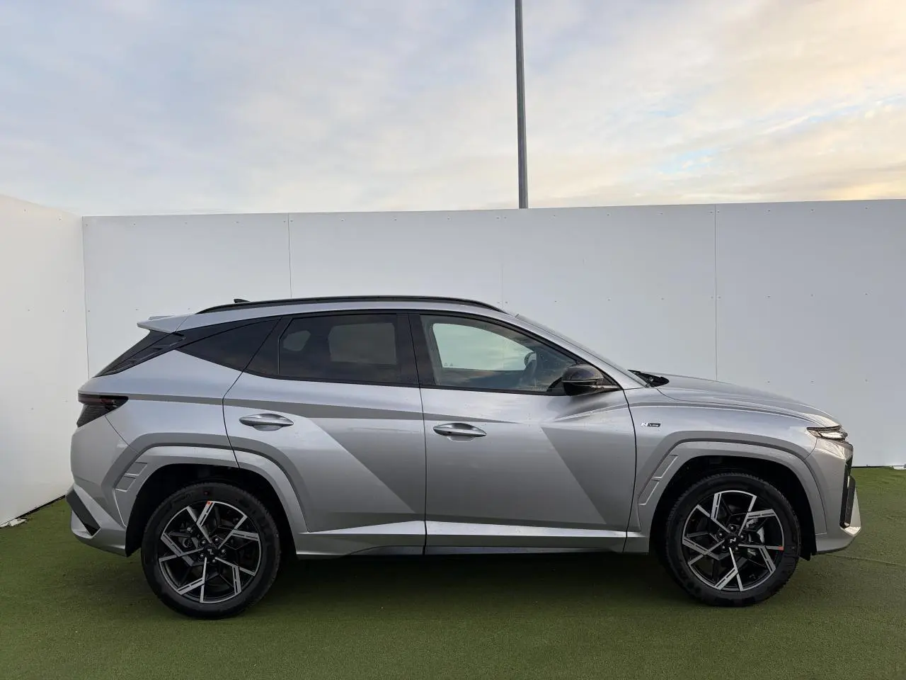 Hyundai Tucson 2025 hybride en Shimmering Silver Metal, vue profil côté gauche avec jantes alliage 19'' N Line.