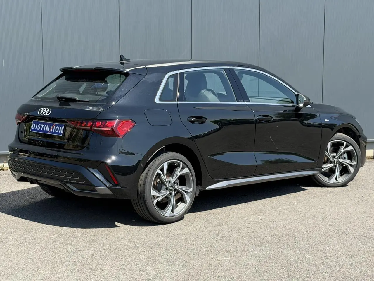 Audi A3 Sportback noir Mythe vue 3/4 arrière droit avec jantes alliage 5 branches en Y brillantes.