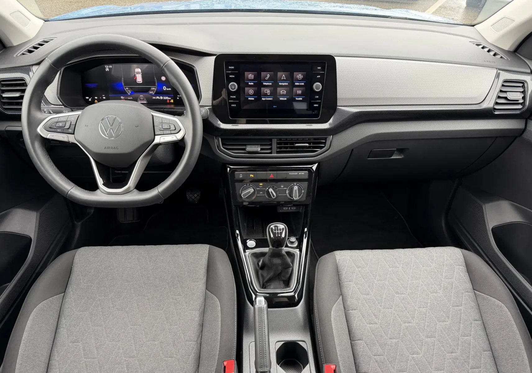 Vue intérieure frontale du Volkswagen T-Cross 2025, volant cuir multifonction, écran tactile central et boîte manuelle.