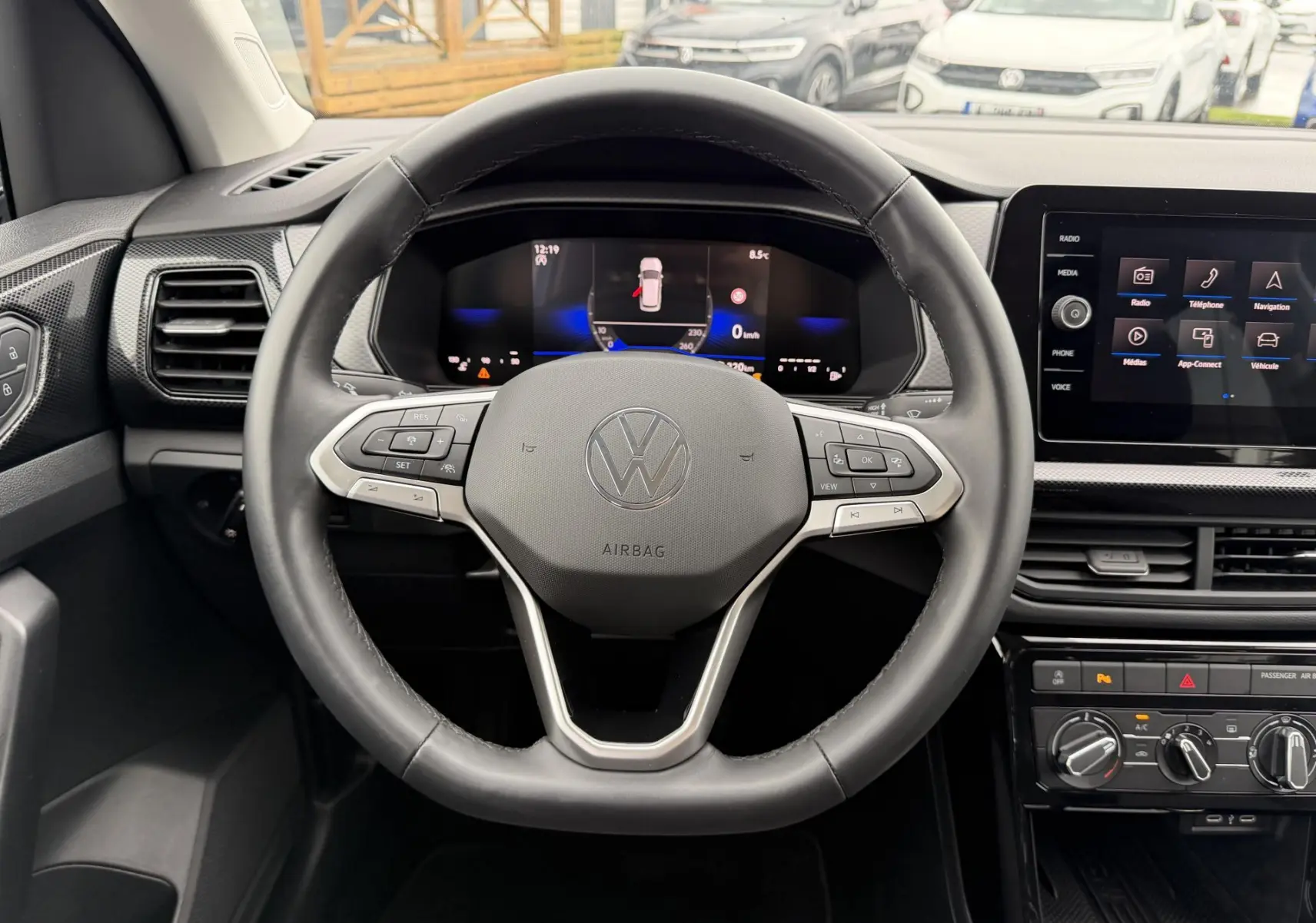 Vue intérieure centrée sur le volant multifonction cuir et le tableau de bord digital du Volkswagen T-Cross 2025.