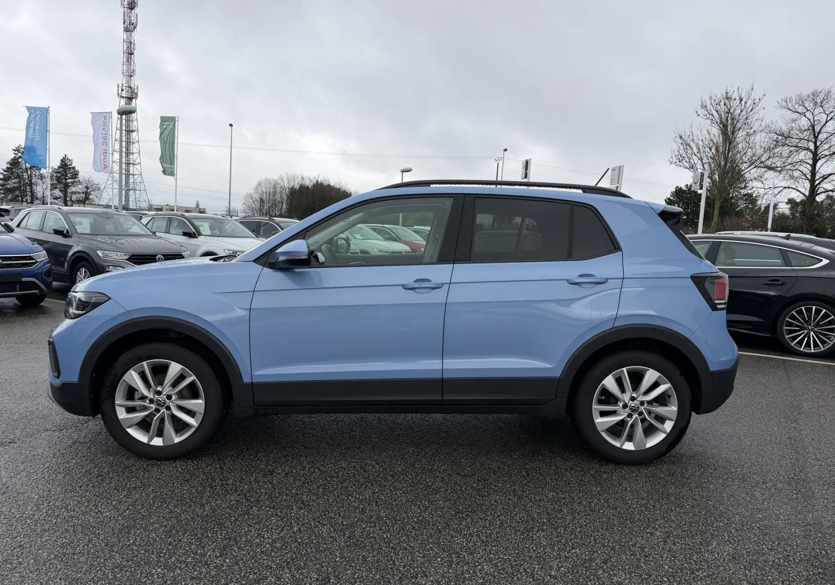 Volkswagen T-Cross bleu en vue profil côté gauche, avec jantes alliage 17 pouces et vitres surteintées.