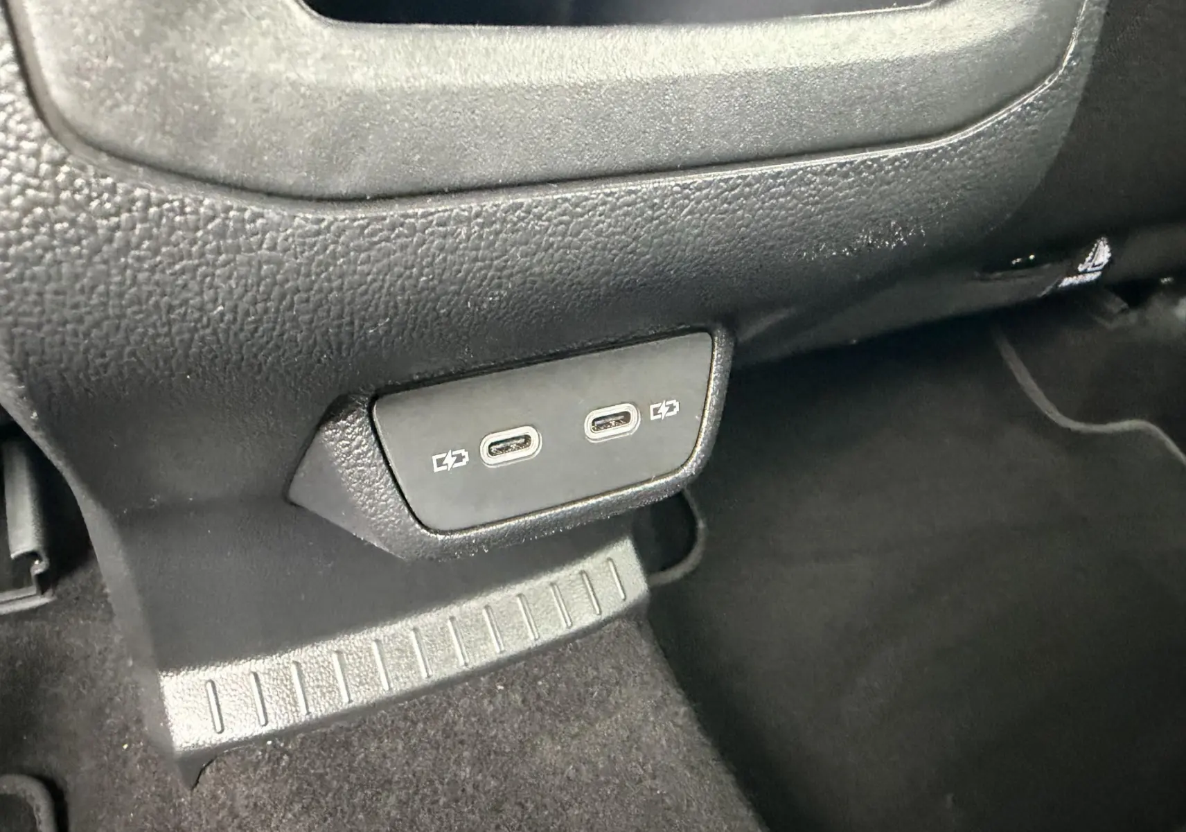 Gros plan sur les ports USB-C situés à l'arrière de la console centrale du Volkswagen T-Cross bleu.