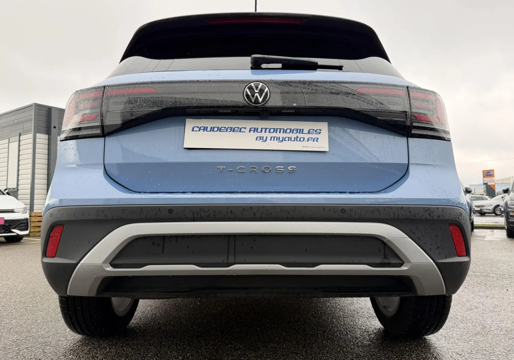 Vue arrière d'un Volkswagen T-Cross bleu 2025 avec feux LED et pare-chocs noir et gris contrasté.