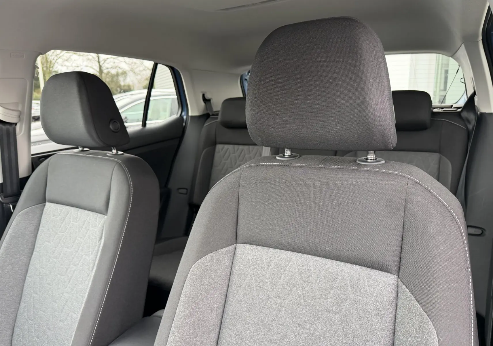 Vue intérieure sur les sièges avant gris foncé et clair du Volkswagen T-Cross 2025, côté droit.