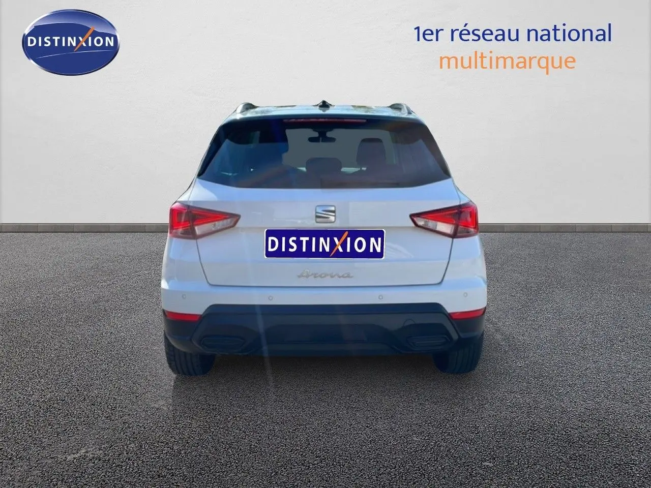 Vue arrière d'un SEAT Arona blanc métal avec toit noir, version Style Special Edition 2025, garé sur sol gris.