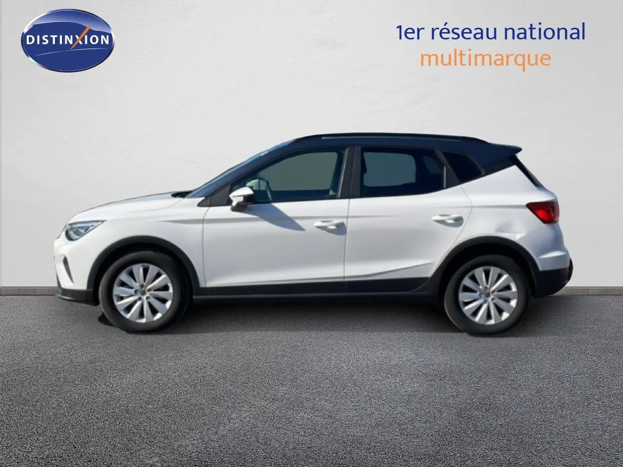 Vue latérale gauche d'un SEAT Arona blanc métal avec toit noir, jantes alliage et détails noirs sur bas de caisse.