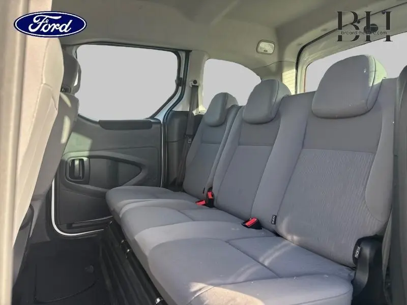 Vue intérieure côté droit montrant la banquette arrière grise du Peugeot Partner Tepee blanc Banquise 2016.