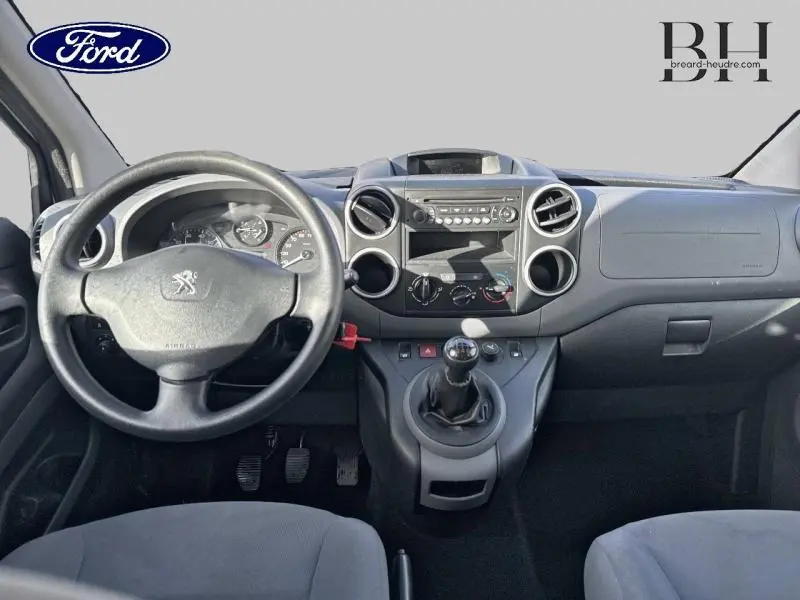 Vue intérieure du tableau de bord et volant du Peugeot Partner Tepee blanc, avec boîte manuelle et commandes centrales visibles.