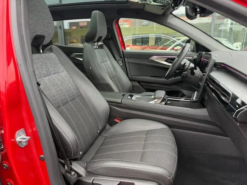 Vue intérieure côté conducteur du Renault Austral 2025 Rouge Flamme, sièges noirs et tableau de bord moderne avec écran tactile.