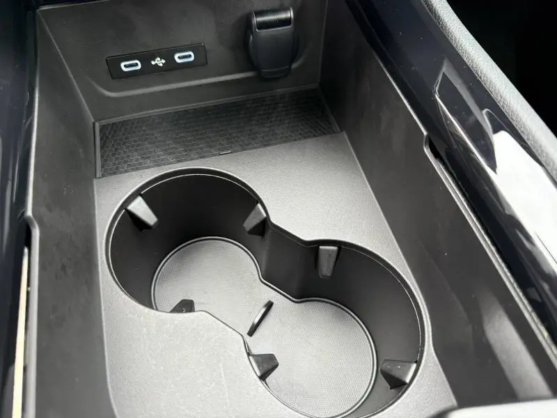 Gros plan sur les porte-gobelets et les ports USB dans la console centrale du Renault Austral 2025 Rouge Flamme.